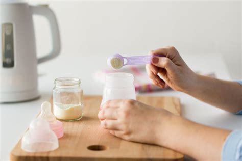 Padres preparando un biberón de leche de fórmula siguiendo las instrucciones