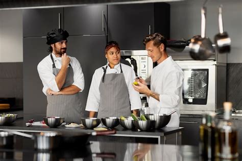 Jóvenes cocinando y trabajando en equipo en una cocina profesional