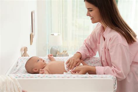 Imagen de padres cambiando pañal a un bebé con expresión de ternura