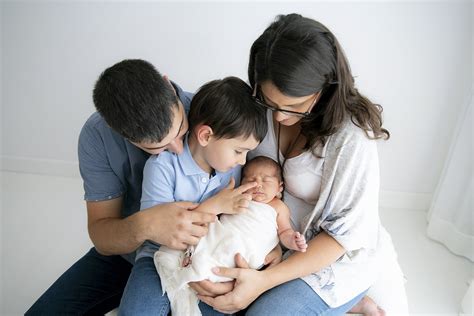 Fotografía de una familia con su recién nacido en una habitación de hospital, o de un equipo de matronas/neonatólogos