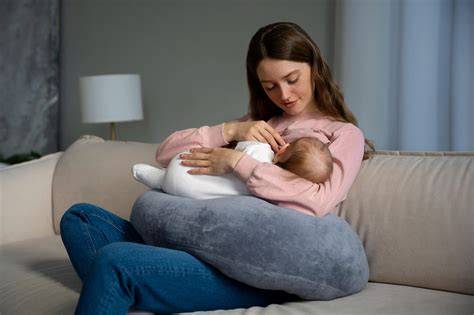 Madre utilizando el cojín TheraNana para amamantar a su bebé, mostrando la ergonomía