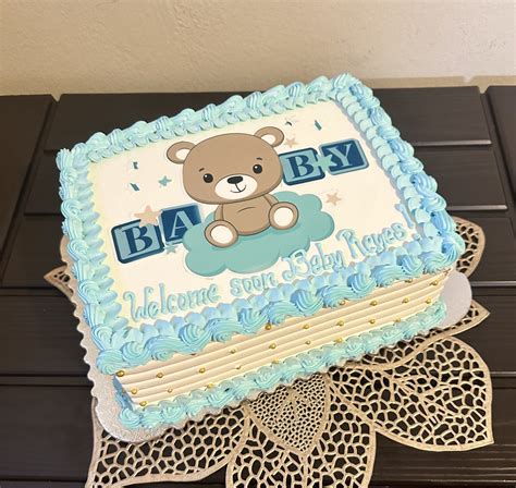 Diseño de pastel de baby shower para niño con motivos clásicos en azul claro y detalles de botones