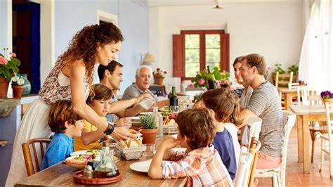 Imagen de una familia comiendo junta en la mesa, promoviendo los hábitos alimenticios familiares.
