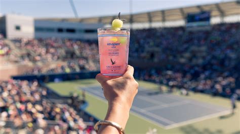 Primer plano de un vaso de Honey Deuce con las bolitas de melón y el logo del US Open