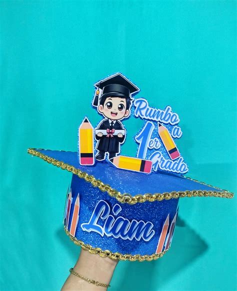 Foto de Salvador con birrete y globos en la cuna decorada
