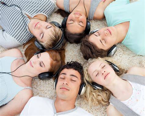 Fotografía de un grupo de amigos escuchando música juntos, simbolizando la colaboración y el disfrute compartido