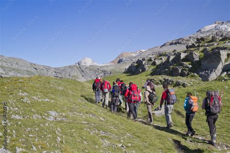 Foto de personas practicando senderismo con botas Meindl en paisajes variados (montaña, bosque, río)