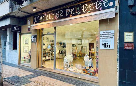 Interior de la tienda Tana Martínez - L’ Atelier del Bebé en Puerto de Sagunto, destacando su ambiente acogedor