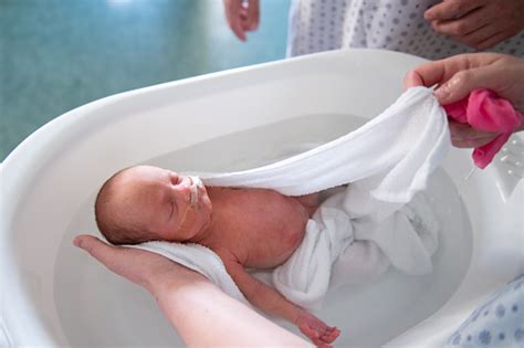 Bebé prematuro recibiendo un baño arropado