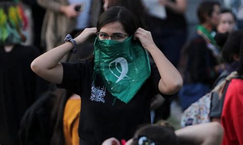 Mujer joven con pañuelo verde en manifestación por el acceso al aborto legal y seguro