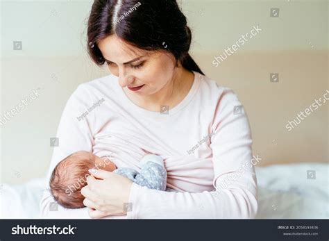 Foto de una pareja de mujeres amamantando a un bebé, una de ellas con un relactador
