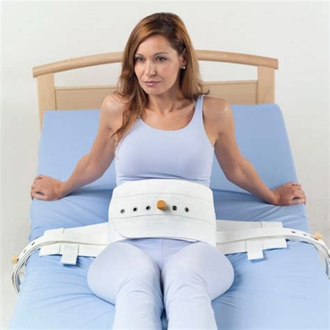 Ilustración de un cinturón de sujeción para cama, mostrando su colocación y la seguridad que ofrece a un paciente.