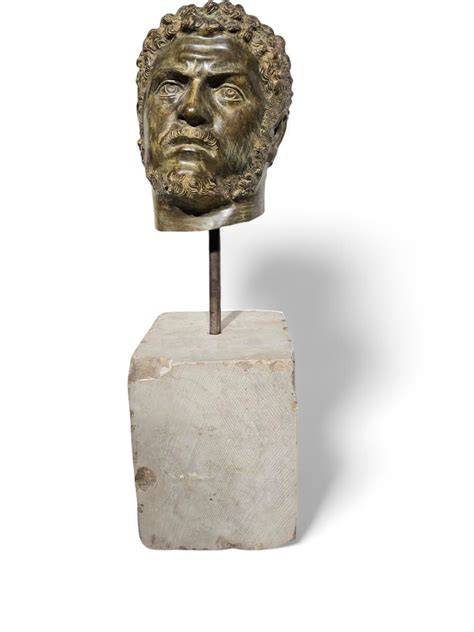 Busto de emperador romano en bronce y una estatuilla decorativa moderna