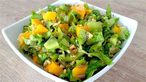 Ensalada fresca con trozos de piña, cubos de queso feta, nueces picadas y hojas de lechuga, aliñada con una vinagreta