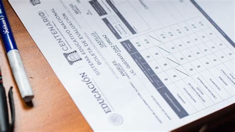 Docentes revisando boletas de calificaciones, con elementos educativos en el fondo
