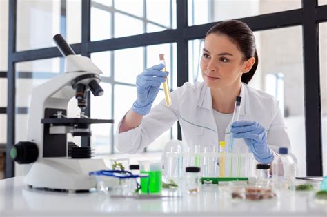Foto de una científica trabajando en un laboratorio, con elementos sutiles de maternidad en el fondo o en el escritorio