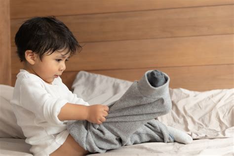 Foto de un niño poniéndose una braga pañal Naty
