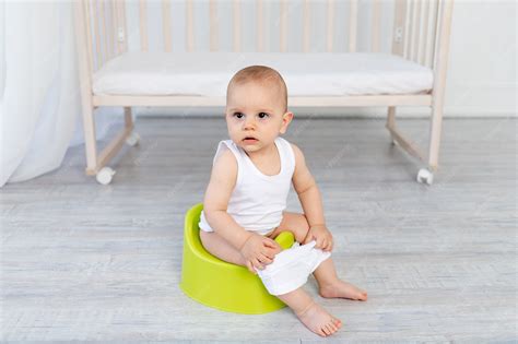 Foto: Niño pequeño feliz sentado en un orinal o váter con adaptador