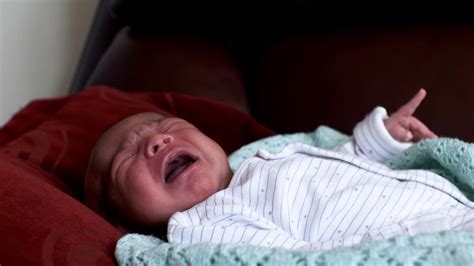 Bebé llorando y encogiendo las piernas, mostrando síntomas de cólico