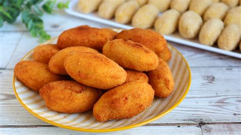 Plato de croquetas de harina de arroz doradas y crujientes sobre una servilleta de papel.