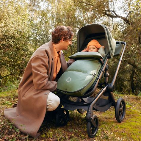 Foto de familia feliz usando un carrito y una silla de coche Bugaboo