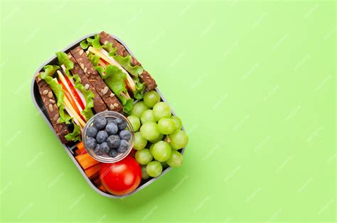 Foto de fiambrera escolar con opciones saludables como un bocadillo, fruta y frutos secos