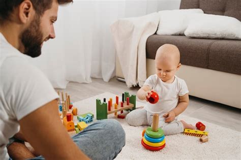 Foto de un padre jugando activamente con su bebé en el suelo