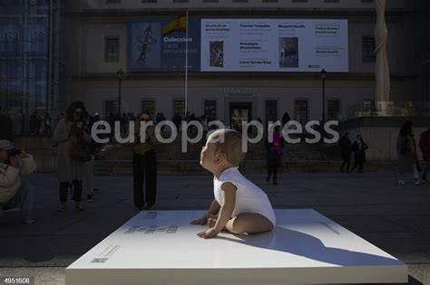 Escultura hiperrealista de un bebé lactante en un espacio público de Madrid