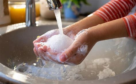 Foto de manos lavándose con agua y jabón antes de preparar un biberón