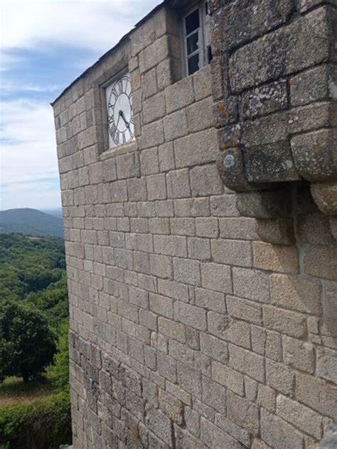 Detalle de la torre del reloj y el escudo del Castillo de Castro Caldelas