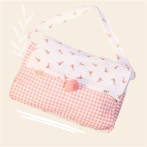 Foto de bolso cambiador de muñecas rojo y blanco con corazones impresos, abierto mostrando accesorios