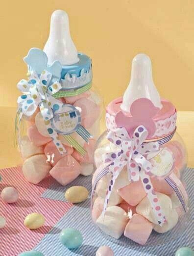 Foto de biberones decorados en una mesa de baby shower, con cintas y etiquetas personalizadas