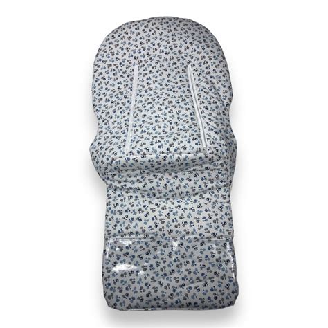 Foto de primer plano de una funda de silla de paseo con estampado de hojas y topos, mostrando los detalles del tejido.