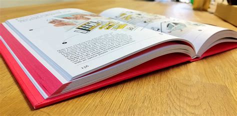 Primer plano de un libro de tapa dura abierto, mostrando una página con texto e ilustraciones personalizadas.