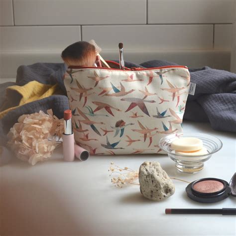 Un neceser de algodón con un estampado de animales, abierto, mostrando productos de higiene para bebé.