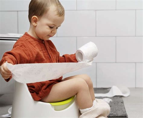 Foto de un niño feliz usando el orinal o en ropa interior de niño mayor