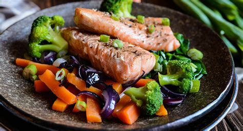imagen de un plato variado con pescado azul, verduras de colores y cereales integrales