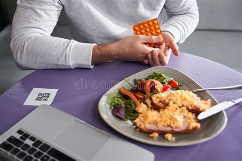 Persona tomando pastillas con comida