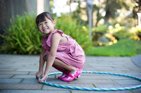 Niño o niña jugando con muñecos gemelos en un capazo, fomentando el juego de rol y la imaginación.