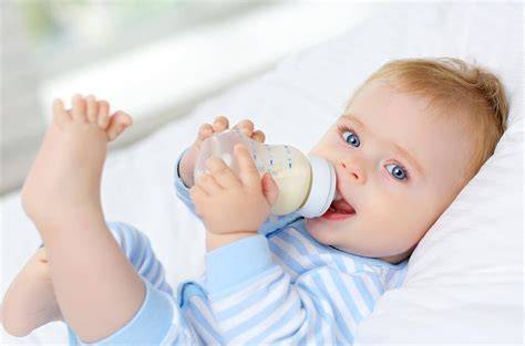 Bebé durmiéndose con un biberón en la noche