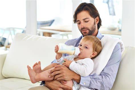 Padre alimentando al bebé con biberón en un ambiente tranquilo