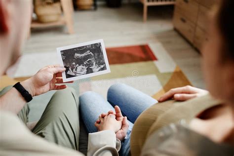 Imagen de una pareja sonriente mirando un ultrasonido de bebé