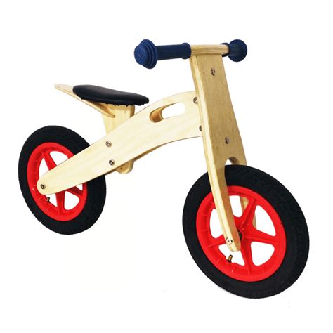 Foto: Niño utilizando una bicicleta de equilibrio de madera en un parque