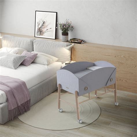 Diseño de una minicuna transparente con detalles en tono beige, mostrando su estructura ligera y visibilidad interior.