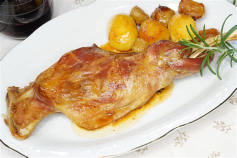 Plato de cabrito lechal asado, dorado y tierno con guarnición