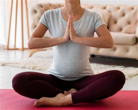 Foto de una mujer embarazada meditando para reducir el estrés