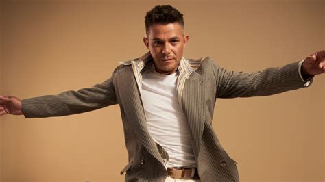 Foto de estudio profesional de Alejandro Sanz en una actitud reflexiva o durante un concierto