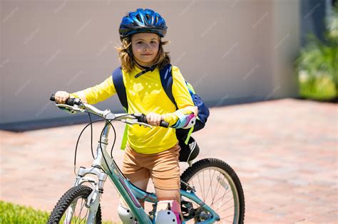 Niño feliz montando una bicicleta sin pedales en un parque soleado, con un casco bien ajustado