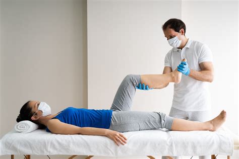 Imagen de una fisioterapeuta realizando terapia manual o guiando ejercicios a una mujer en postparto