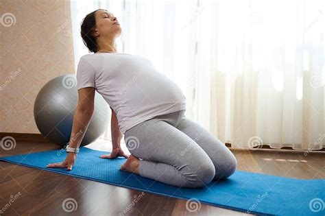 Mujer embarazada practicando yoga prenatal para aliviar el dolor de espalda